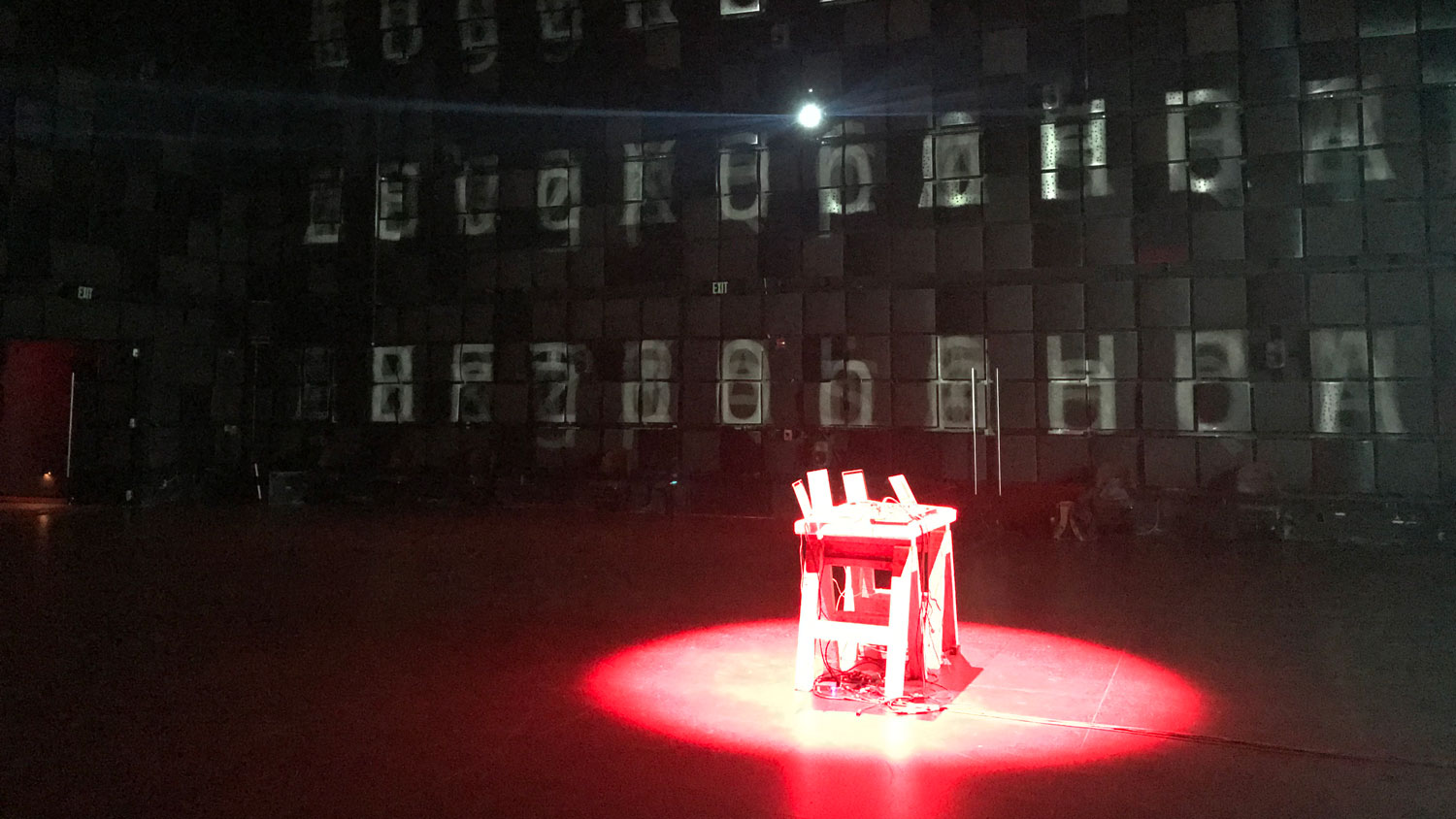 a table bathed in red light in the middle of a black box studio